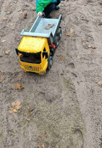 Dziecko bawi się samochodem na placu zabaw