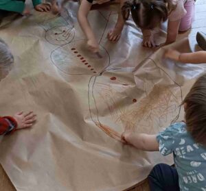 Dzieci rysują bałwan an szarym papaierze