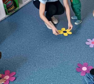 zabawa ruchowa dzieci bawią się na dywanie kwiatami