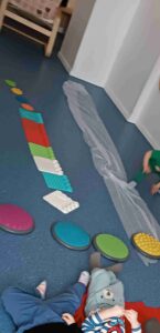 Tor przeszkód ułożony z kolorowych kafli i kostek o różnych fakturach.