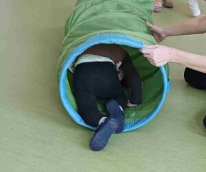 Dziecko pokonuje materiałowy tunel