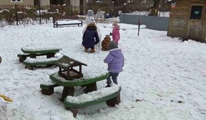 Dzieci bawią się na śniegu.